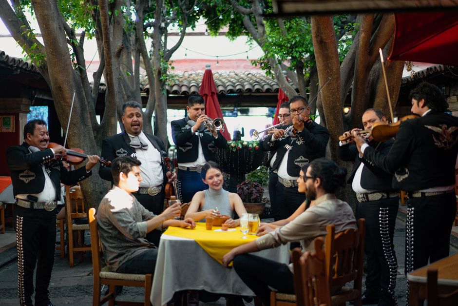Mariachi band serenades diners at a festive Mexican restaurant gathering.