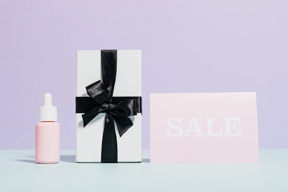 Elegant gift box with black ribbon beside a sale card, perfect for promotions.