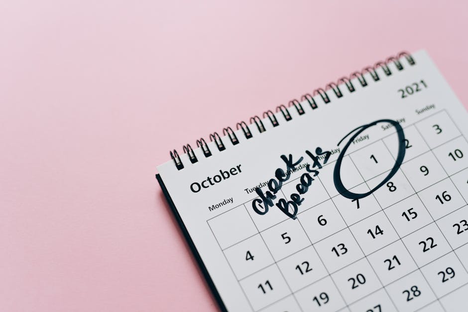 October calendar with breast check reminder, emphasizing health awareness on a pink background.