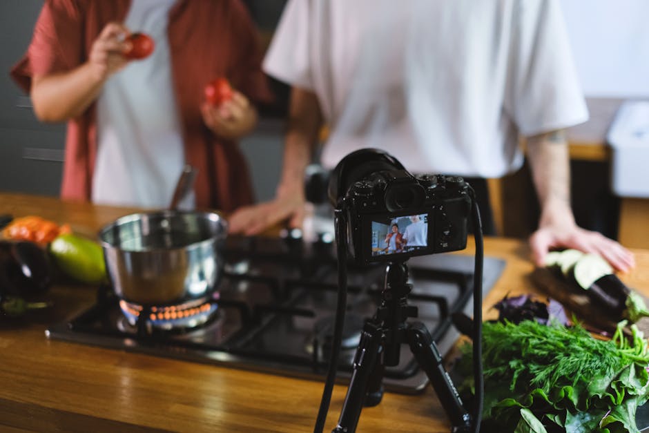 Two people filming a cooking video with fresh vegetables and a camera setup on tripod.