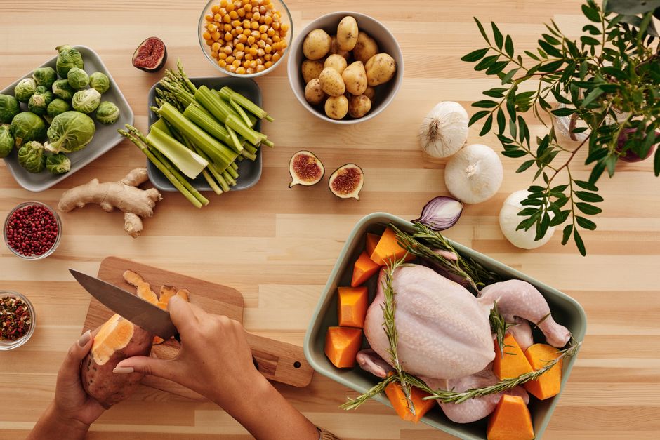 Top view of hands preparing ingredients for a roast with fresh vegetables.