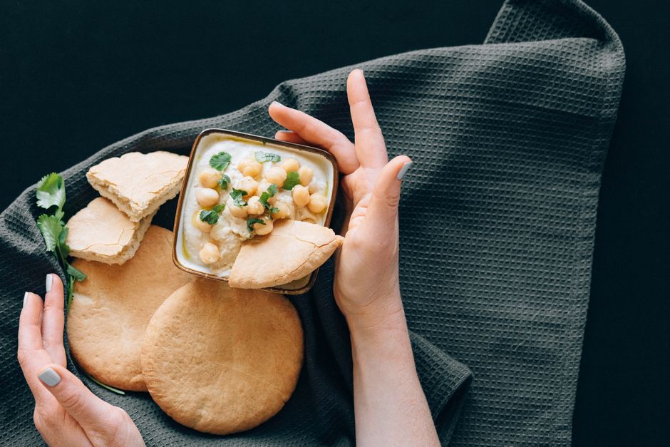 Delicious hummus with chickpeas served with freshly baked pita bread. A healthy Middle Eastern appetizer.